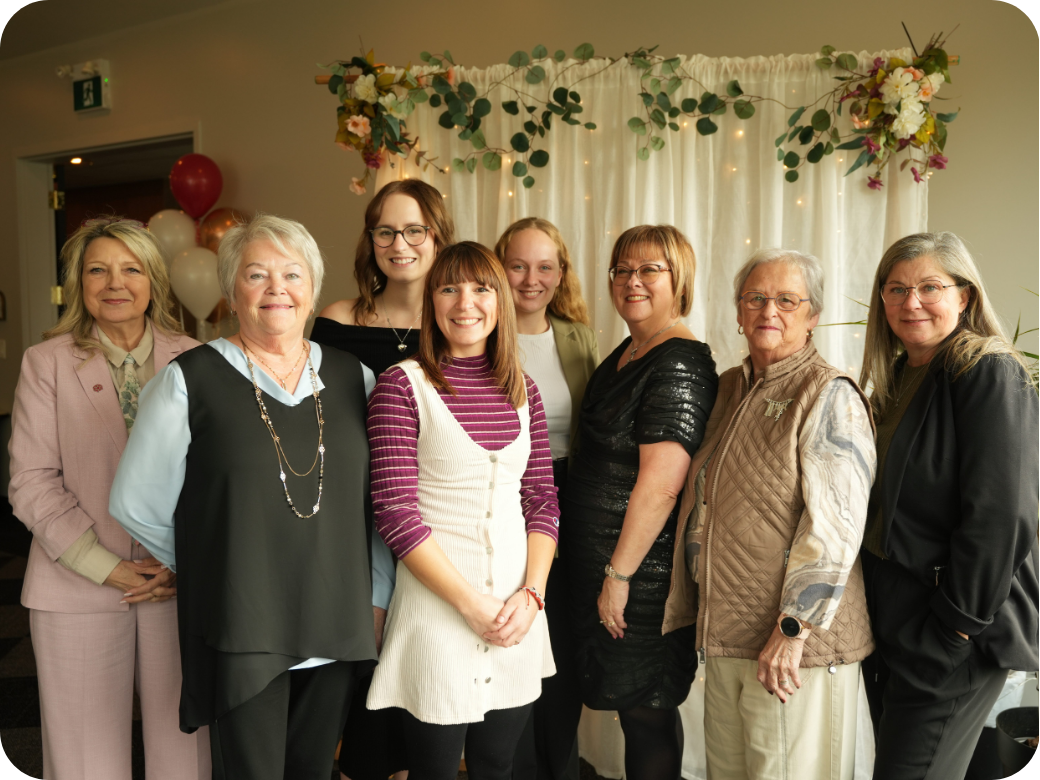 Groupe de personnes souriant.es qui regardent la caméra